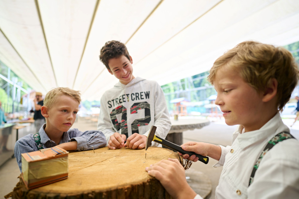 Children participating in a traditional craft workshop at the Solčava Days family event in Logar Valley, Slovenia.