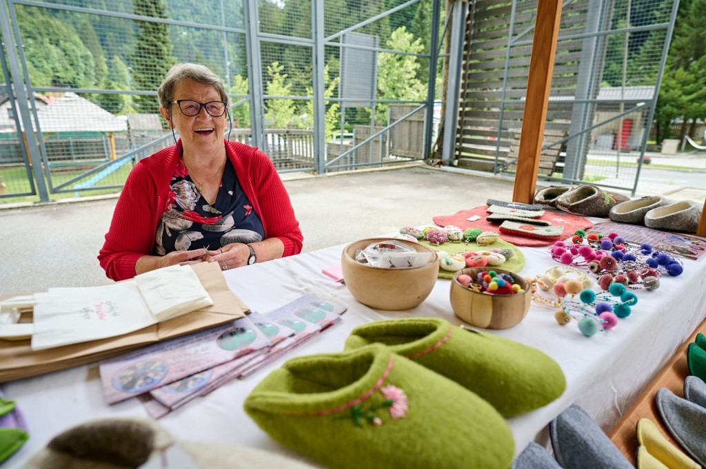 Local artisan presenting handmade wool products at the Solčava Days event in Logar Valley, Slovenia.