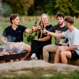 Friends enjoying drinks around a fire pit at Wine Paradise Glavinič