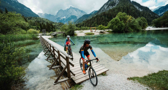Two cyclists are cycling across the Jasna Lake in Kranjska Gora