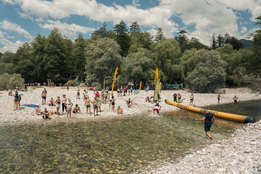 Tekači v cilju Soča Outdoor Festivala prečkajo reko Tolminko