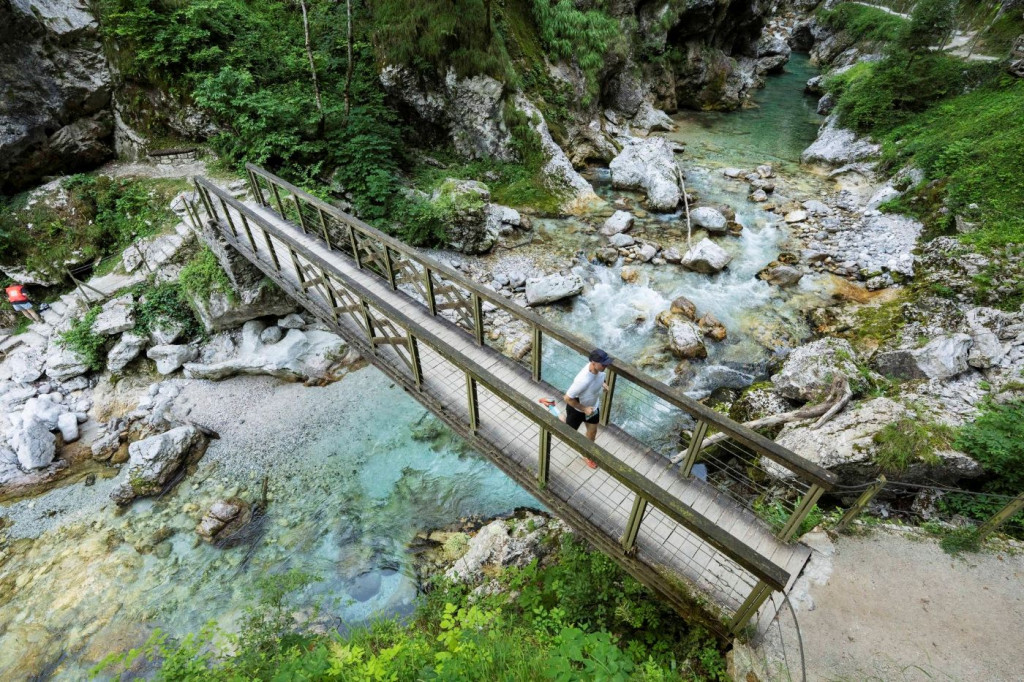 A man crossing the Tolminka river at the wodden bridge in the Tolmin Gorges